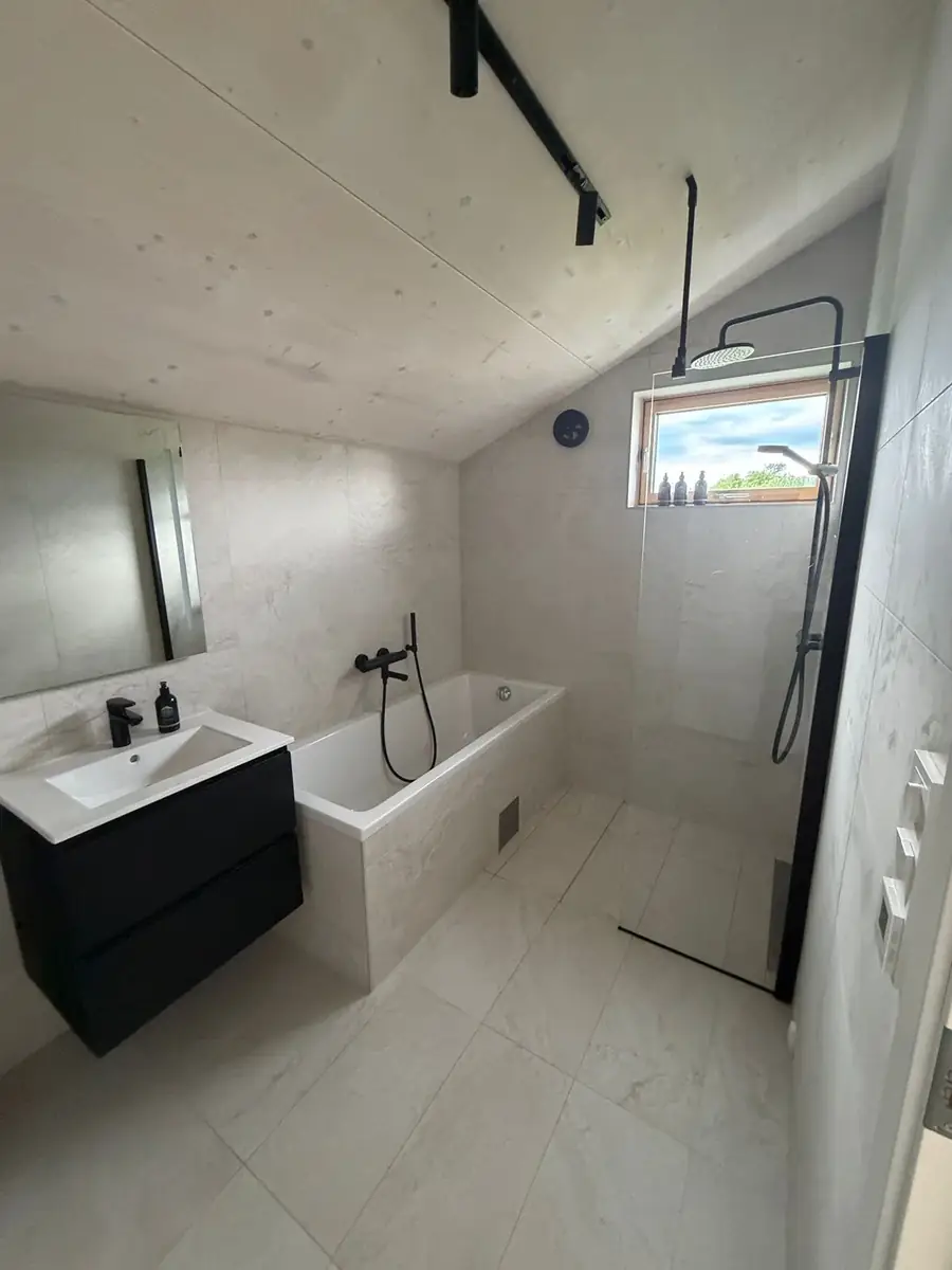 Badezimmer mit Wanne und Regendusche